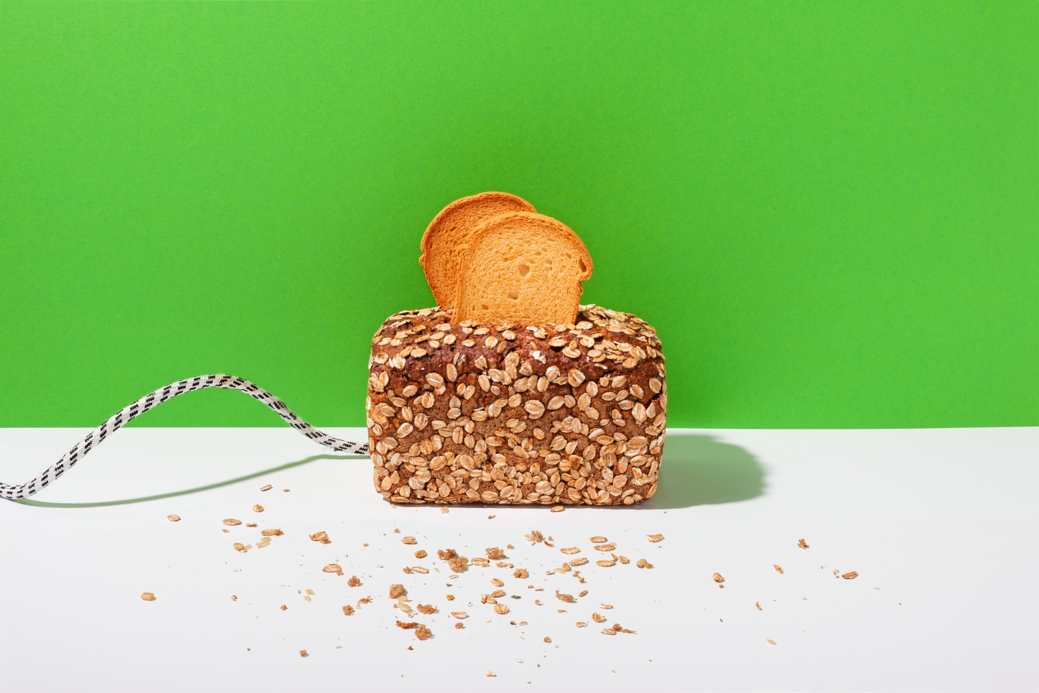 Als Toaster gestaltetes Brot vor grünem Hintergrund